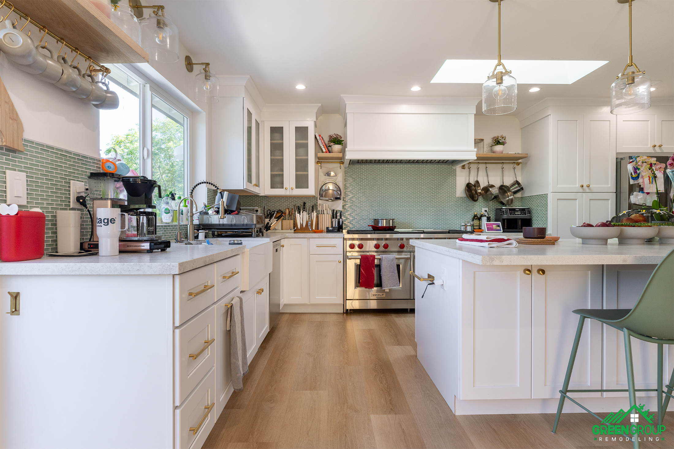 11 Common Kitchen Renovation Mistakes to Avoid. Image of a kitchen with white cabinets and countertops, mint green backsplash, and gold accents.